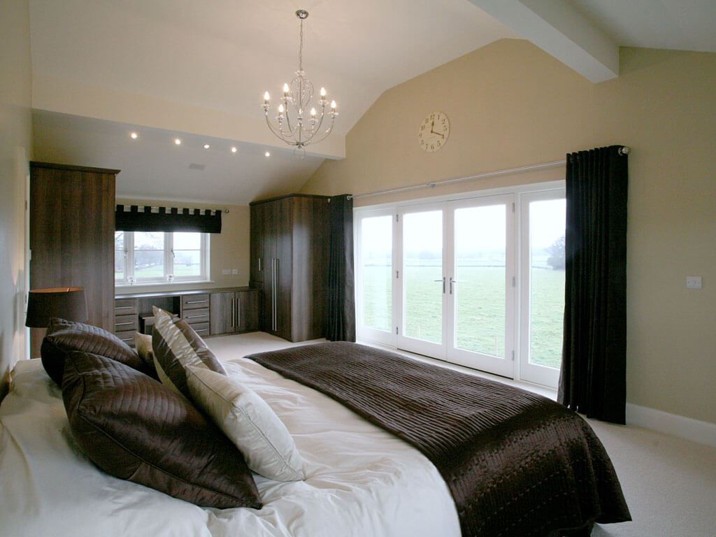 A large modern bedroom with dark brown textile accents