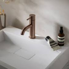 A simple metal tap is mounted in a rectangular sink